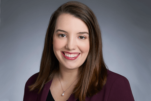 Jessica Benham, a smiling white woman with medium-length brown hair wearing a burgundy blazer.