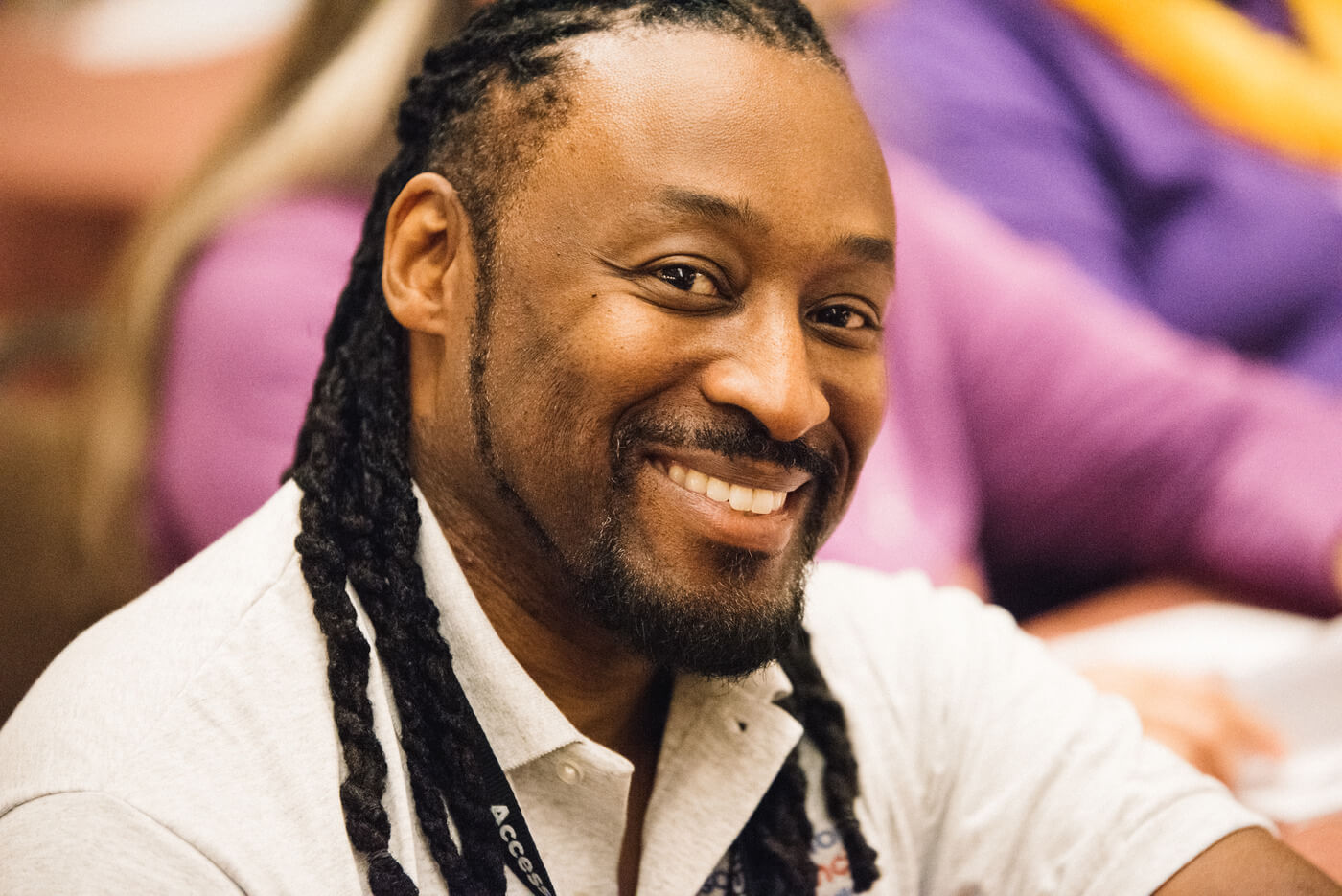 A Black advocate with long black braids smiles at the camera.