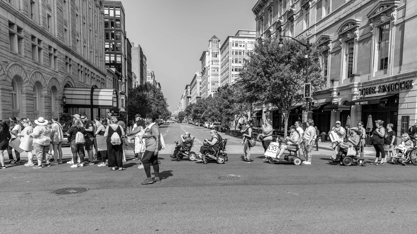 A black and white photo of advocates marching.