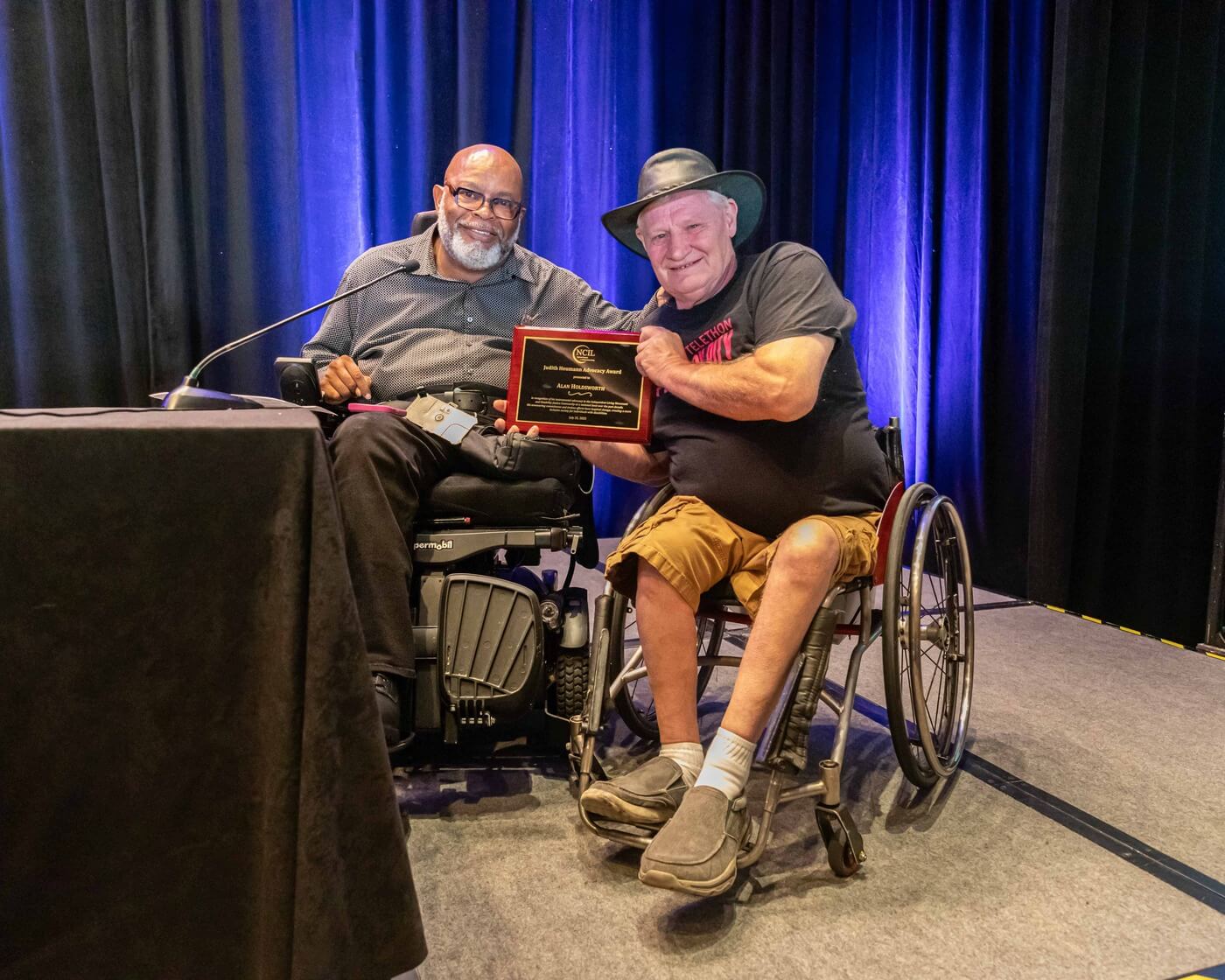 Theo Braddy and Alan Holdsworth pose together, with Alan holding his Judith Heumann Memorial award.