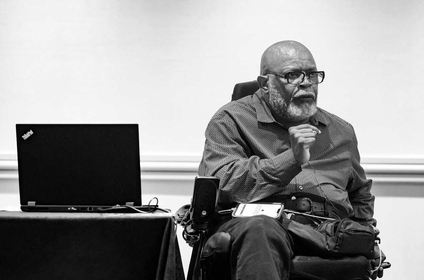 A black and white photo of Theo Braddy presenting at the NCIL conference.