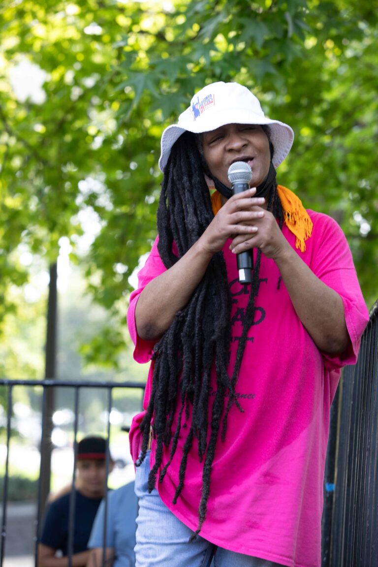 Woman on stage near the capitol holding a microphone.