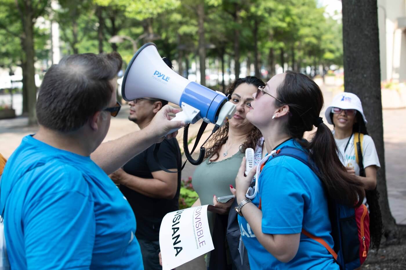 A group of advocates hold up a bullhorn.