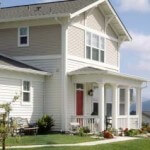 A home with a zero step entrance provided by a concrete walkway leading to a front porch