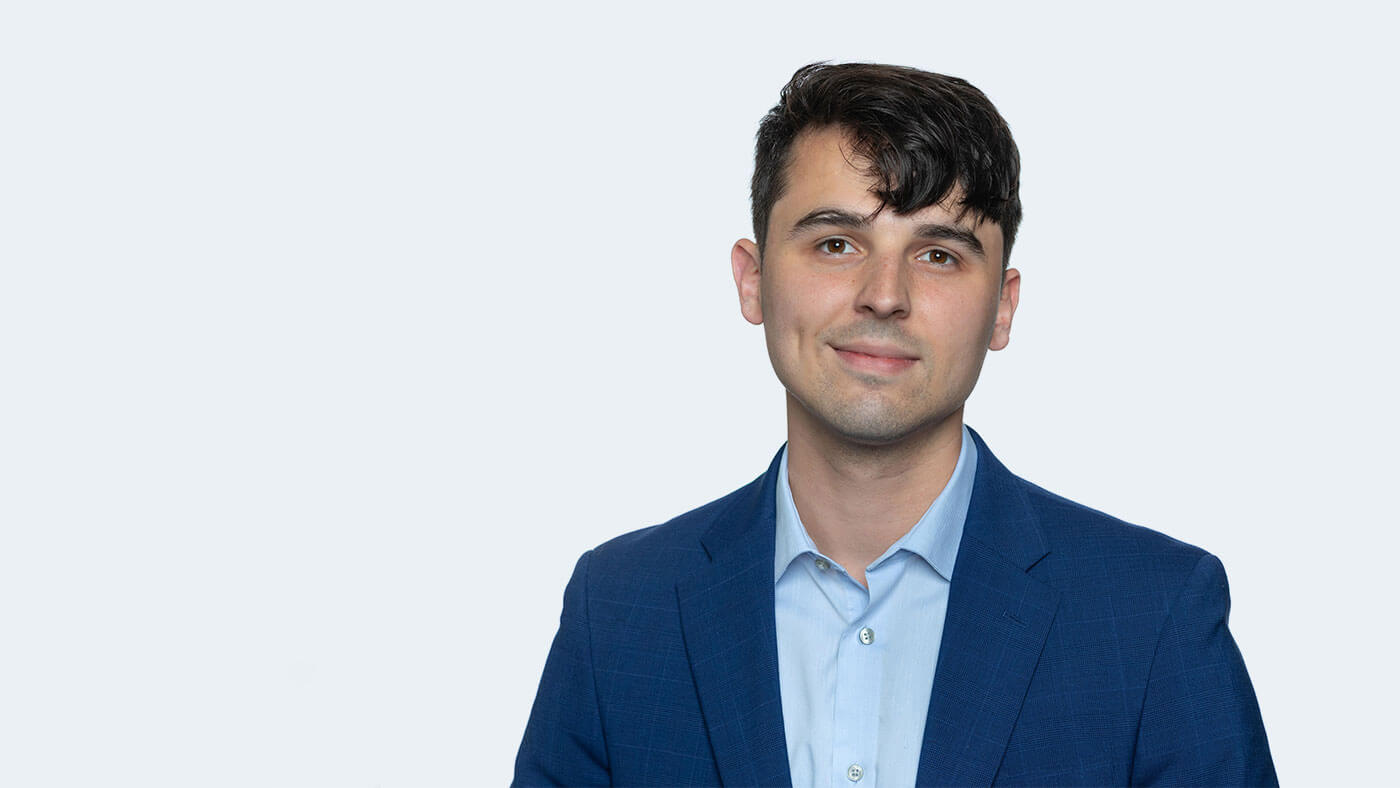 Harm Tarrant, a white person with short black hair, smiles at the camera.