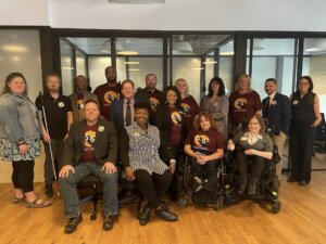sixteen advocates pose for a group photo. Several are wearing shirts with the 5 for 5 Logo.