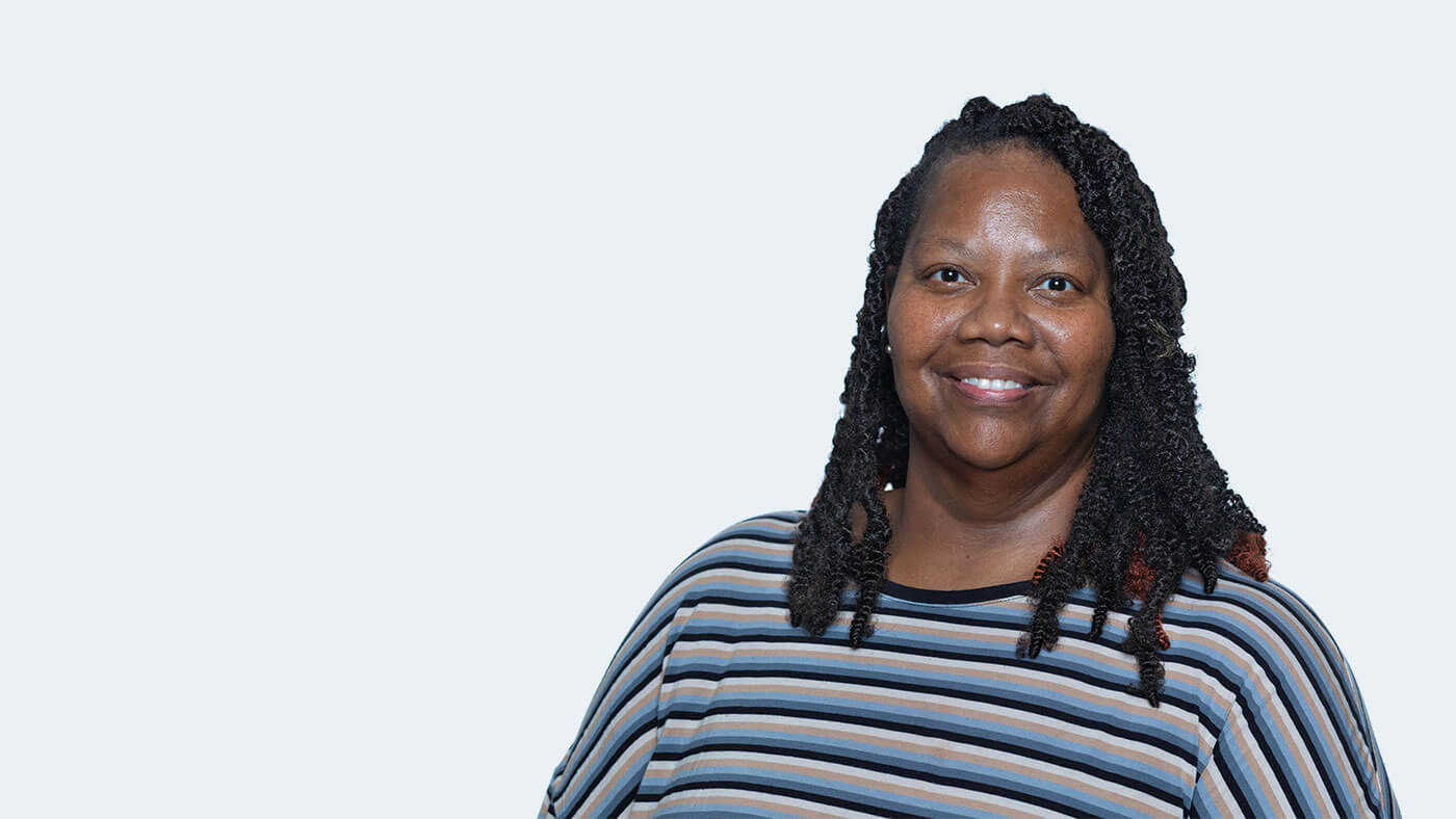 Lateefah Hunt, a Black person with braids just past her shoulders, smiles at the camera.