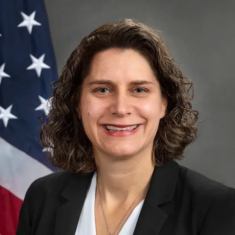Alison Barkoff poses for an official head shot with the American Flag behind her