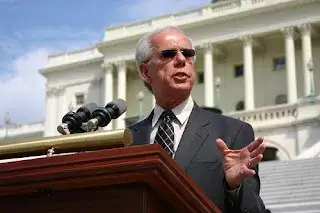 Tony Coelho speaks from a podium outside the U.S. Capitol