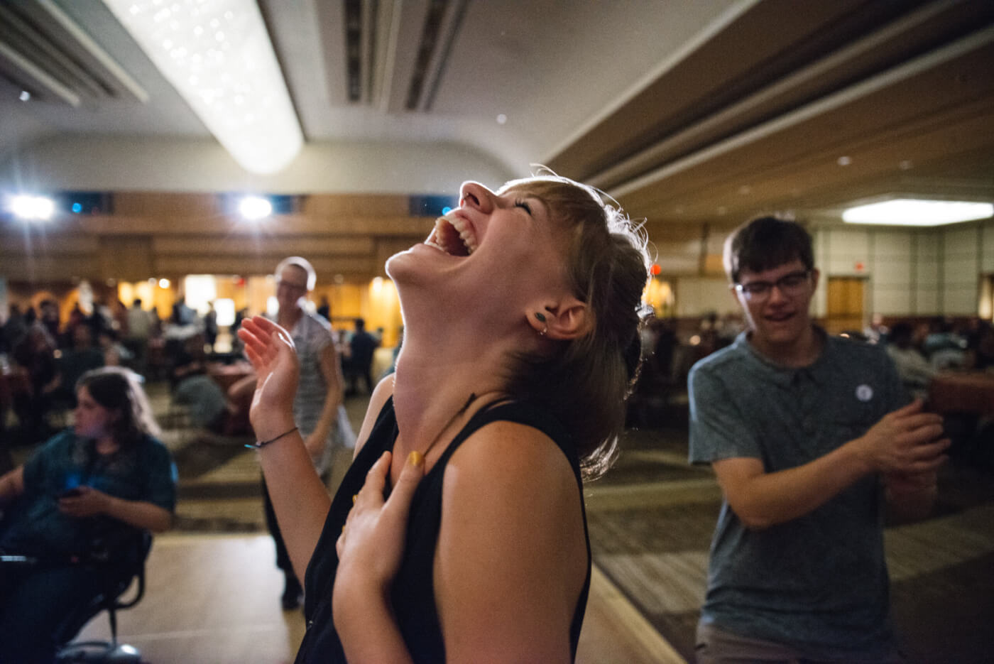 Fel Agrelius throws their head back in laughter from the dance floor of the NCIL Annual Conference.