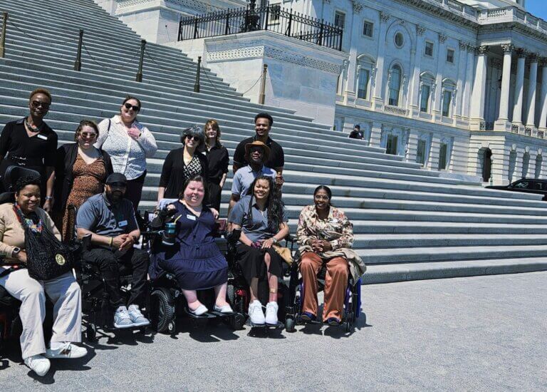 Eleven people from Independence Now in Silver Springs, Maryland gather together for a group photo with the U.S. Capitol behind them during a Congressional visit.