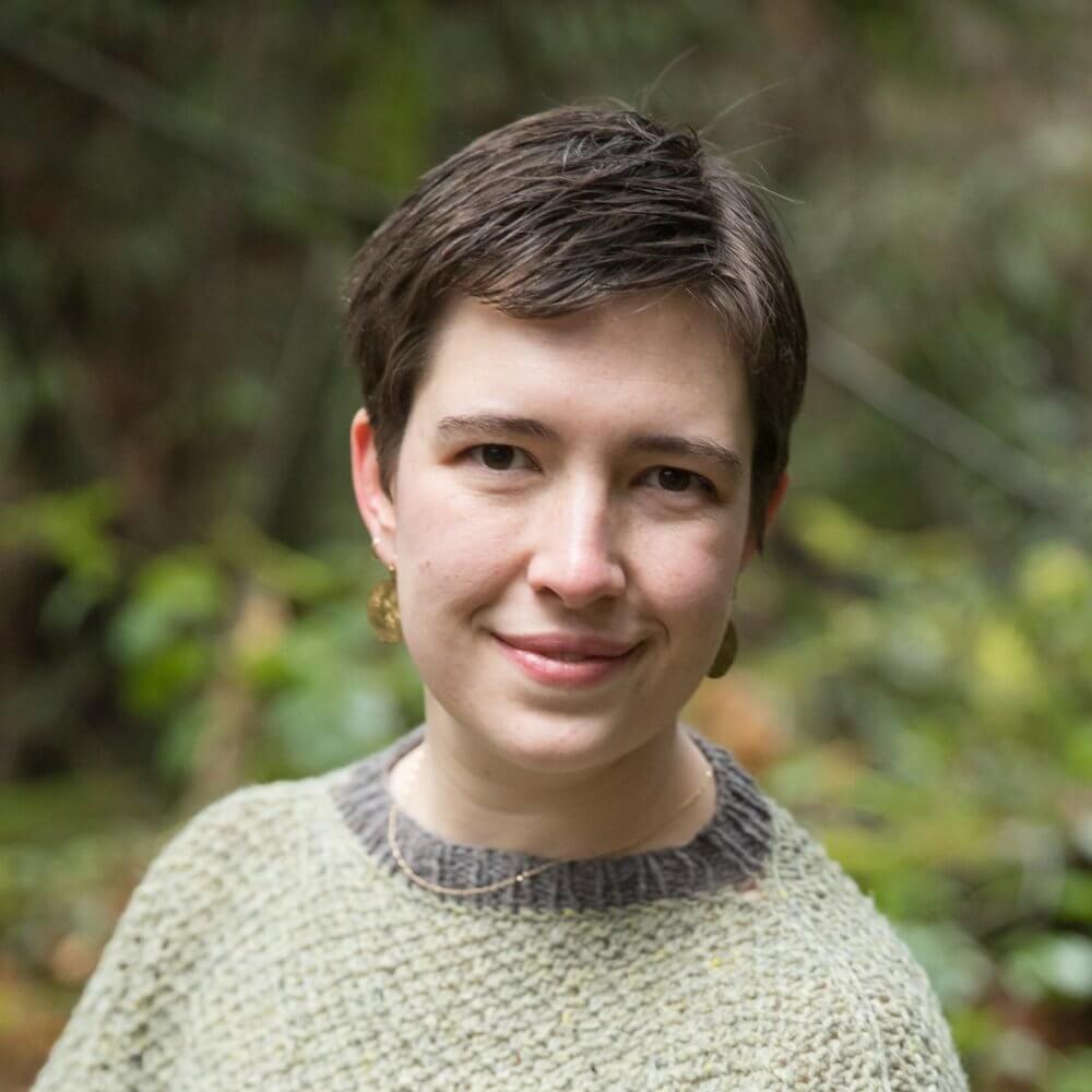 Leanna Namovic: White woman in her late 20’s with short light brown hair and a kind smile