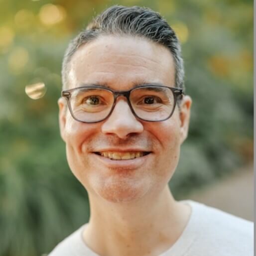 A middle-aged white male with short brown hair, wearing glasses and smiling for the camera.