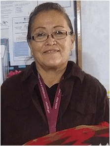 A woman holding a woven blanket, smiling