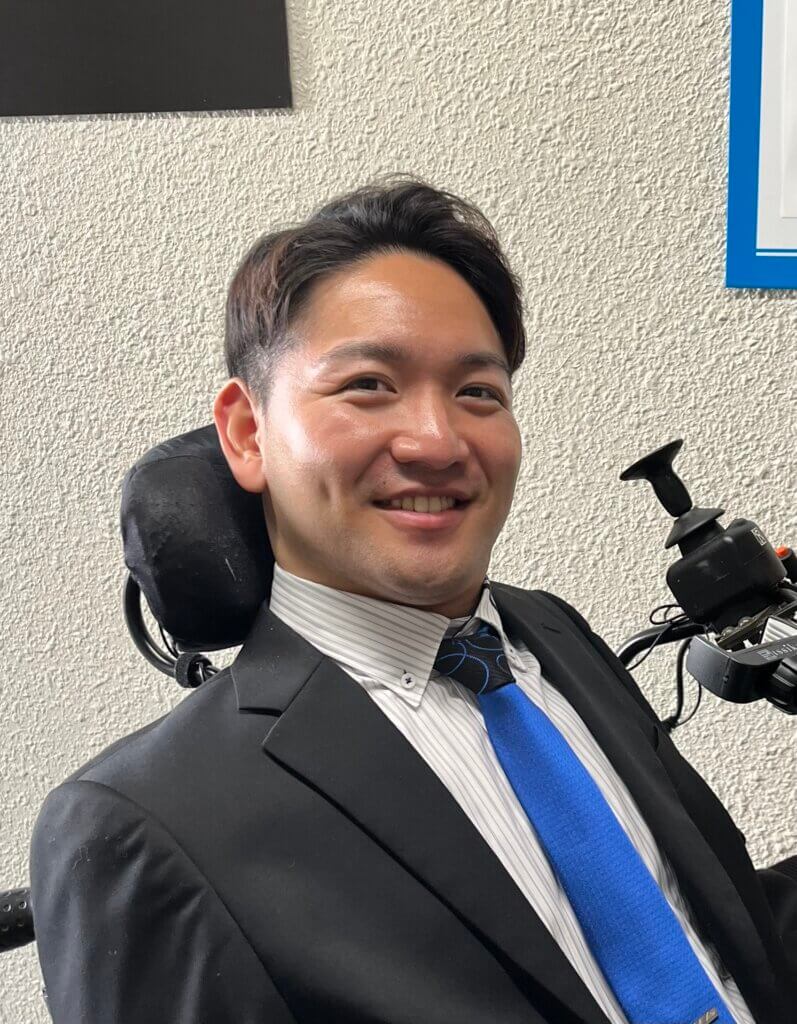 A headshot of an Asian man in his late 20s with short black hair, smiling for the camera.