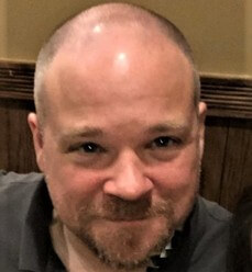 Paul, a smiling white man with a beard and shaved head.